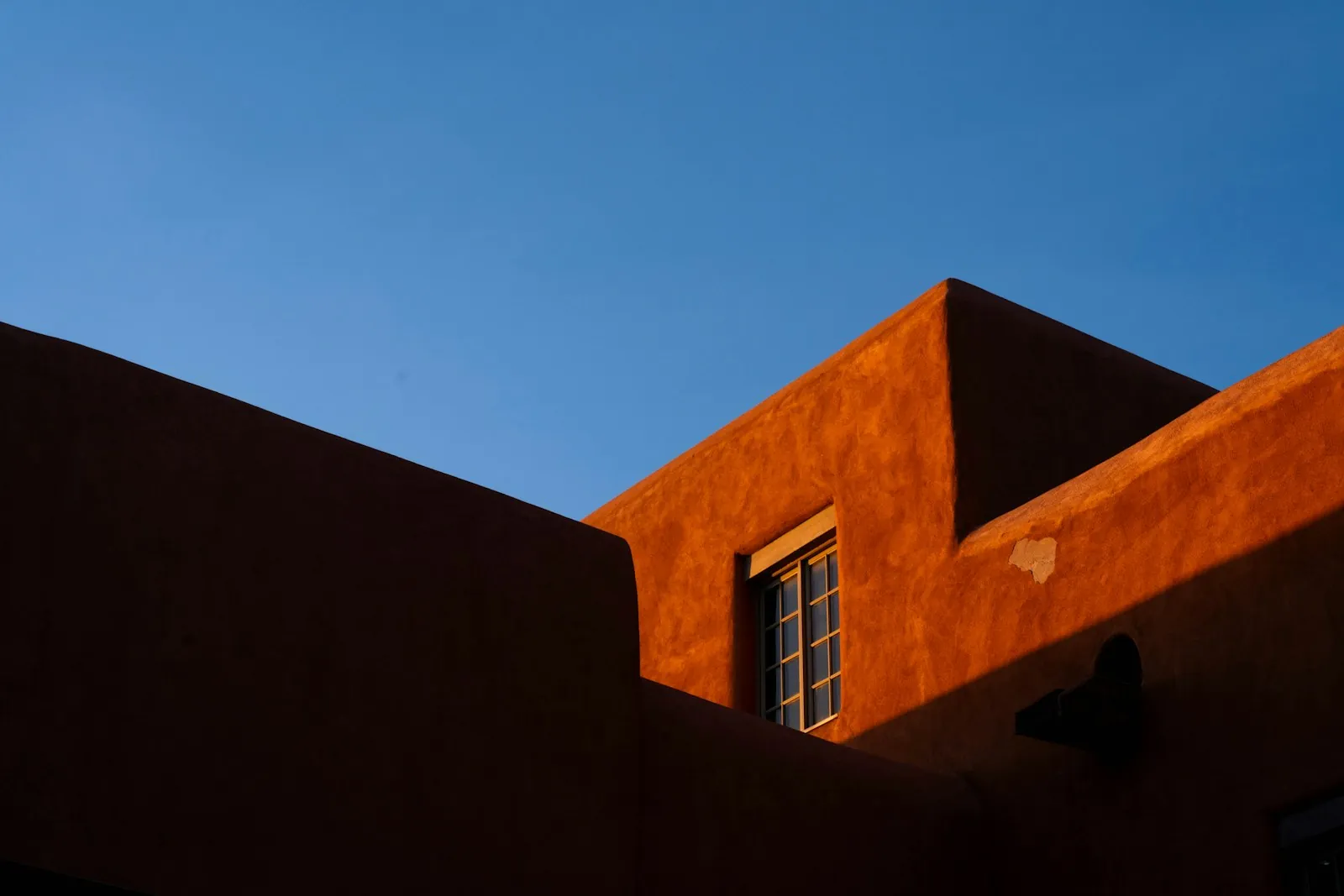 Fachada en terracota con esquina viva y sombra de alero
